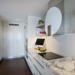 Fitted kitchen cabinetry with Stone bench tops and decorative exhaust fan