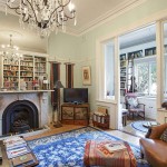 Mirrored panel to chimney breast to reflect built in bookcases